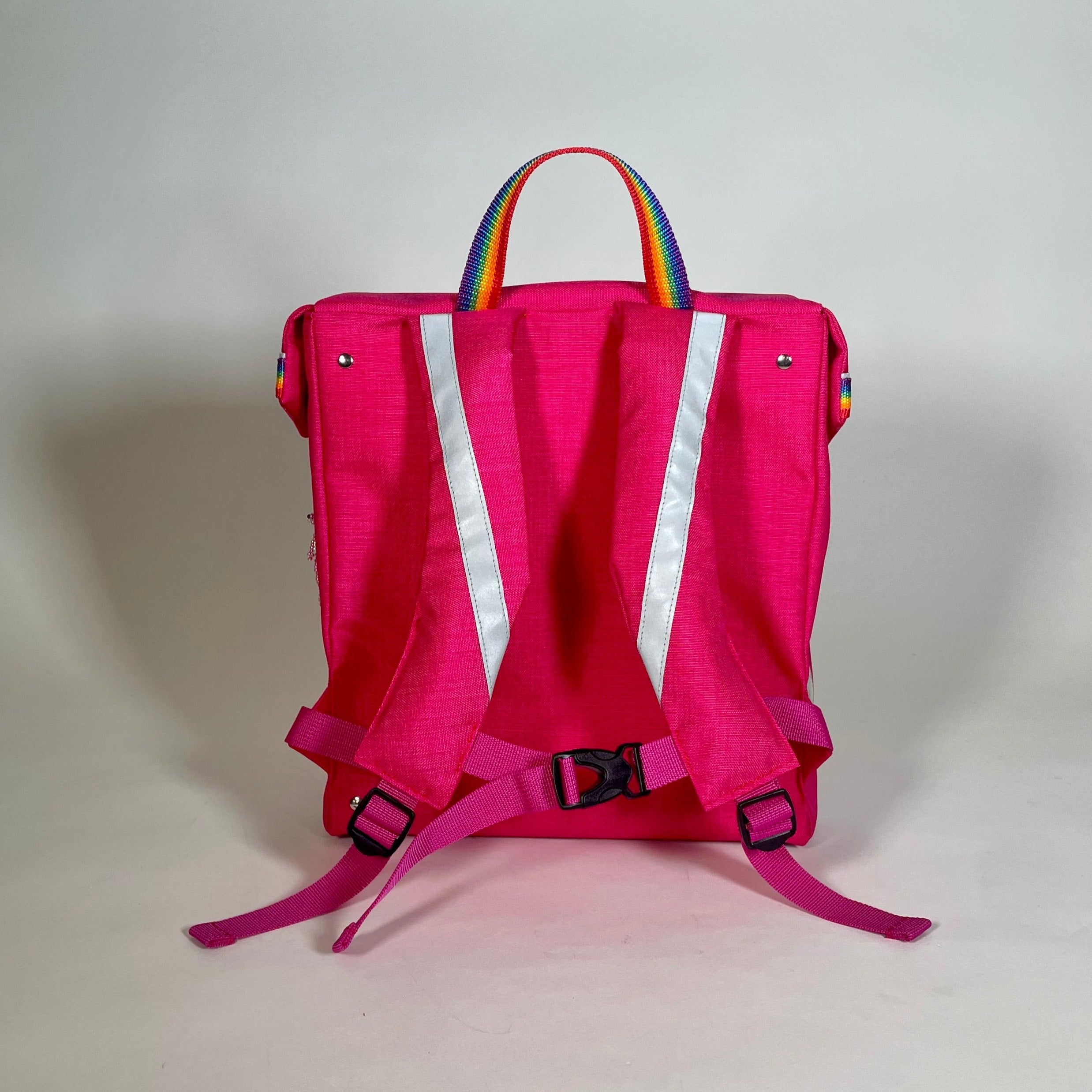 Rückenansicht eines pinkfarbenen schlichten Schulranzen für Erstklässler. Schlicht, leicht, mit praktischer Innenaufteilung und vielen Reflektoren